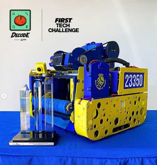 Team 23350's yellow and blue DECODE robot beside its Central Regional Championship Inspire 2nd place trophy