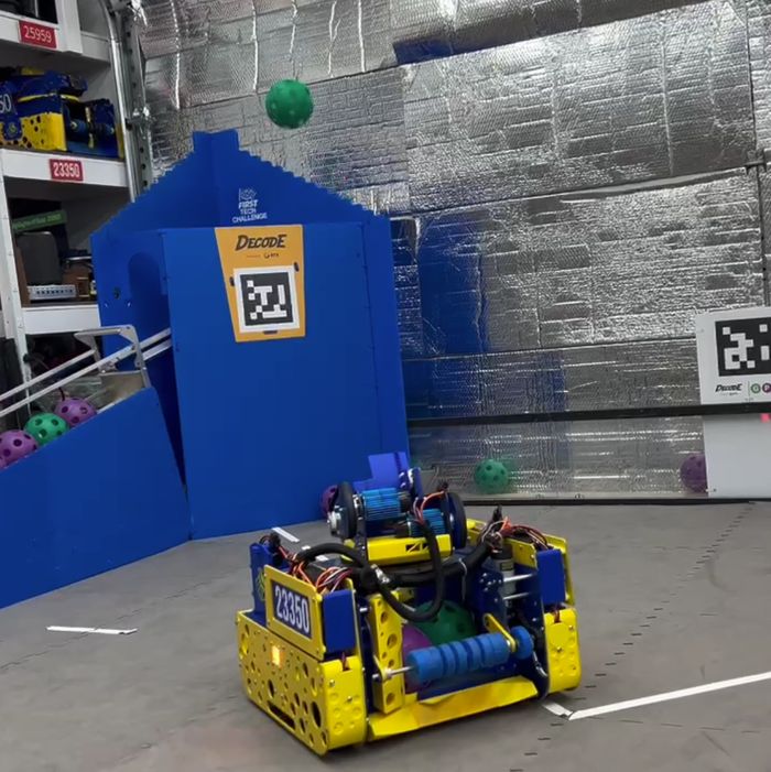 Cypher driving in front of the blue goal as a ball flies overhead