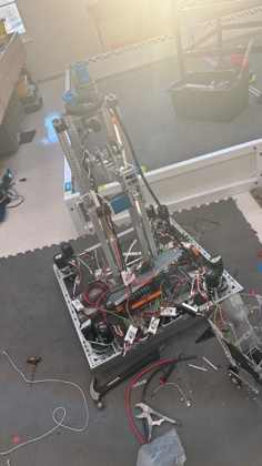 A robot mid-assembly with a tall arm, NEO motors and wiring