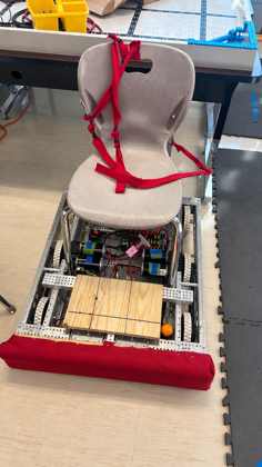 A rideable robot: a school chair strapped to a chassis with a wooden deck